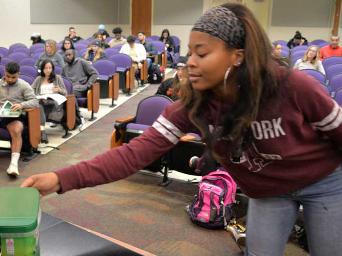 Angelique James, a sophomore majoring in mass communications in the Richard T. Robertson School of Media and Culture, donates pocket change to a fundraising effort led by her statistics professor, Rebecca Durfee.